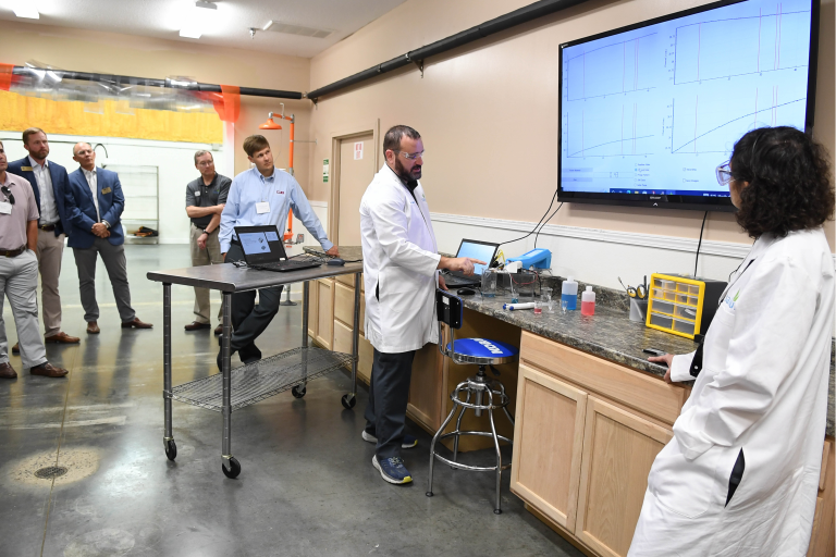 The Salvus team shows how the target substance is detected using the flow cartridge and handheld device for guests during the Salvus open house on Nov. 3 in Valdosta, Ga.
